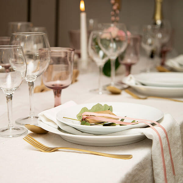 Hvid hørdug og serviet med rosa vinglas